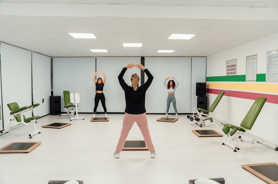Small group of coworkers exercising together in an office gym space