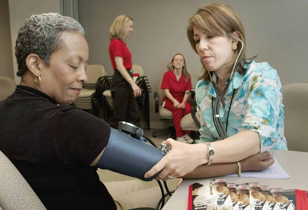 Nurse measuring blood pressure of an employee during a health screening