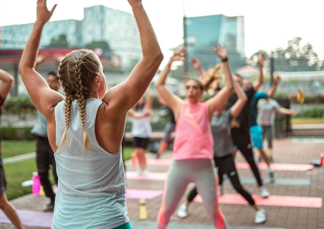 Corporate wellness coach guiding a small group fitness session